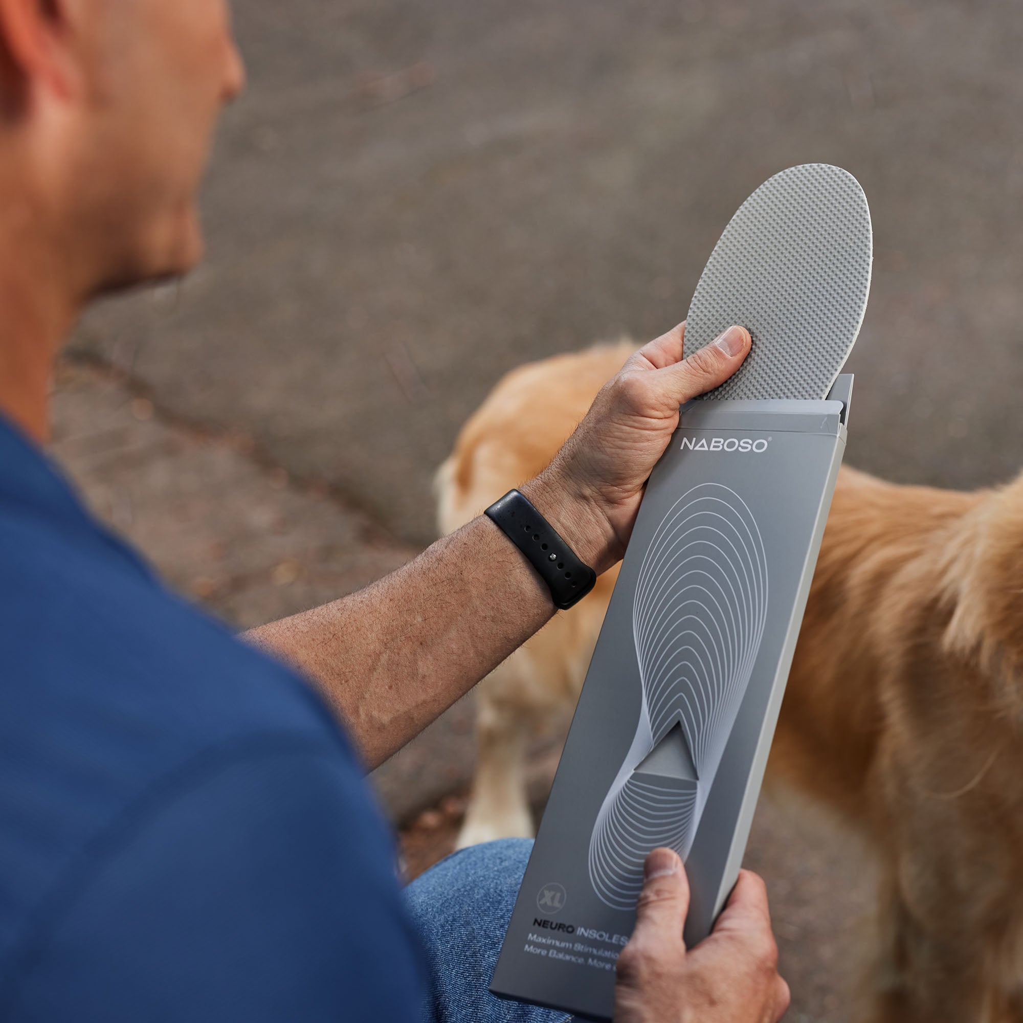 A man taking the grey Naboso Neuro Insoles out of their packaging